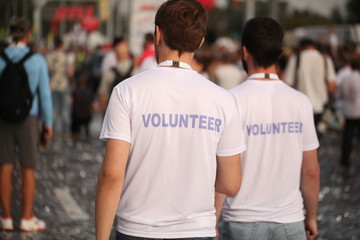 Men in T-shirts with the inscription Volunteers at a sporting public mass event competition