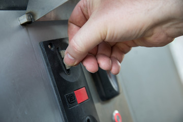 Mann wirft Münze in Autowäsche SB Waschbox Münzautomat ein um Auto zu waschen
