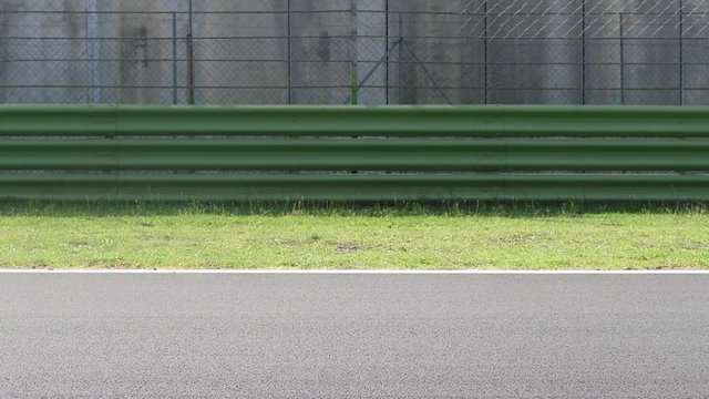 Racing cars on straight asphalt track racing circuit, slow motion side view