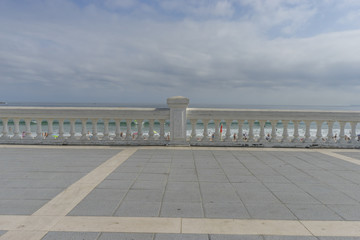 seafront promenade at Playa del Sardinero, view of the beach with a stone railing and the sea in the background, Santander, Spain