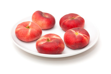 Flat peaches isolated on a white studio background.