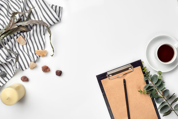 Blank opened notebook with cup of coffee on white table. Top view. Writing concept