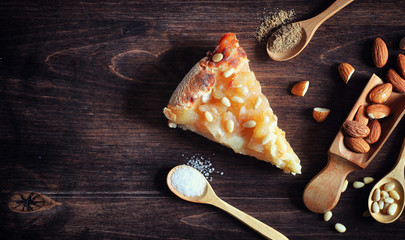 Charlotte with apples and nuts. Preparation of apple baking with nuts and honey. Dessert baked goods from apples and nuts with honey on wooden table.