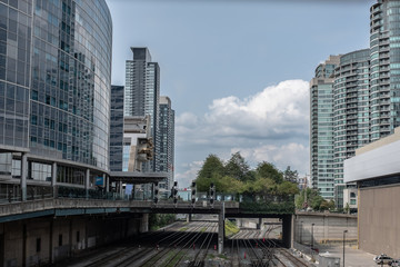 Fototapeta na wymiar Train tracks running between large buildings inner city