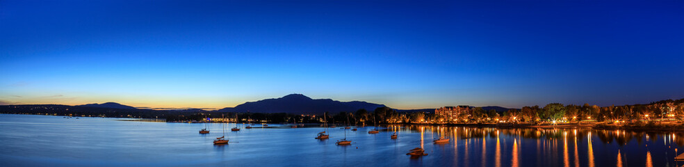 Magog town at night in reflections of Memphremagog lake. Canadian romantic landscape with...