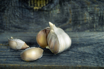 fresh garlic and some cloves of garlic close-up on wooden backgr