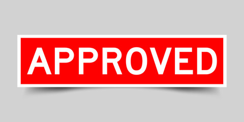 Red sticker with word approved on gray background