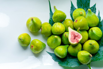 Fruits of fig tree with leaves on white background/ Fresh figs with leaves on rustic table/ Healthy lifestyle concept / Healthy food concept