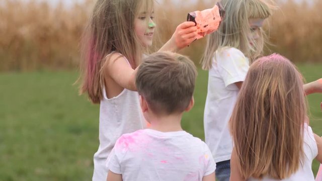 Children play chase throw toss up each other holi colors powder paint have fun outdoors
