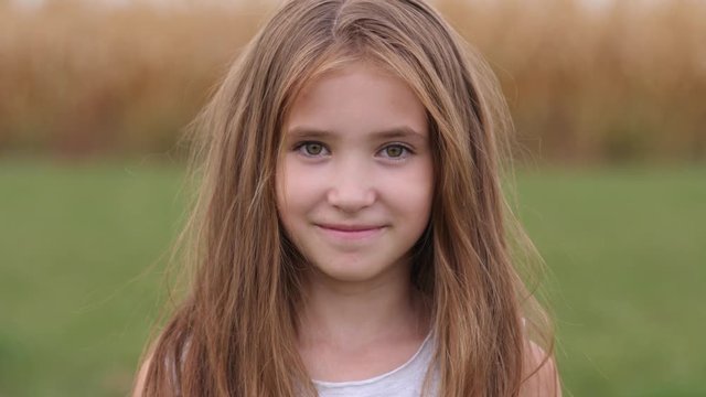 Cute smile child girl portrait posing on nature - happy childhood