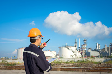 Engineer working in the oil refinery with talking controlling work
