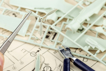 kit for assembling gray plastic airplane model on white bsckground