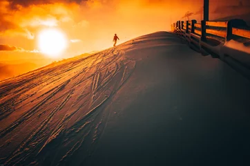 Photo sur Aluminium Sports dhiver Snowboarder in ski resort. Winter sport photo. Orange sunset light in background. Edit space