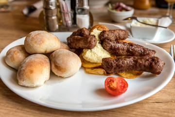 Plate with cevapcici, minced meat kebab with chips on a table