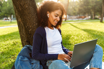 African young woman listening music with earphones.