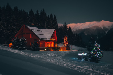 Weihnachtshäuschen in dunkler Winternacht in den Bergen