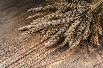 Wheat ears on a wooden background. Vintage composition.