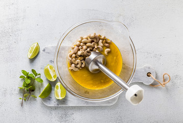 Preparation of vegan paleo cream from cashew nuts and mango puree. healthy alternate raw food with hand blender