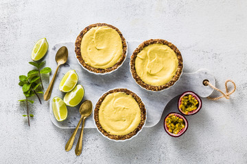 vegan raw mini tarts from nuts and dates with cashew cream from mango purée with lime juice and...