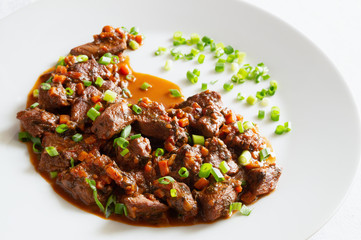 veal stewed with vegetables, herbs and red wine decorated with green onion 