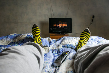 man with pop corns is watching tv in living room, point of view