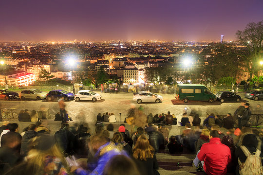 Fototapeta Artist plays music on the stairs of the Sacre-Coeur at Montmartre with tourists listening in Paris, France, on February 23, 2014  
