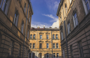 Fototapeta na wymiar narrow european city street buildings facade from below in symmetry geometric corner shape 