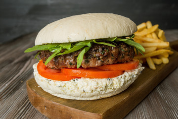 White hamburger and french fries on a wooden background.