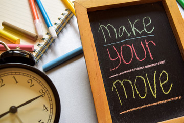 Make your move on phrase colorful handwritten on chalkboard, alarm clock with motivation and education concepts.