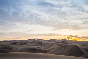 Obraz na płótnie Canvas Coucher de soleil et dunes de sable dans le désert de Huacachina au Pérou Aventure Excursion 