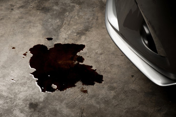 Oil leak or drop from engine of car on concrete floor , check and maintenance auto service
