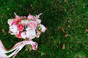Obraz na płótnie Canvas Wedding bouquet of roses on green grass