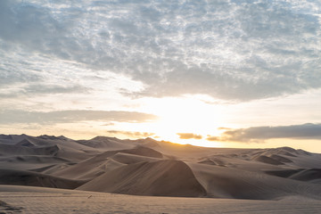 Fototapeta na wymiar Coucher de soleil et dunes de sable dans le désert de Huacachina au Pérou Aventure Excursion 