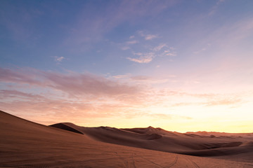 Fototapeta na wymiar Coucher de soleil dans le désert de Huacachina au Pérou Aventure Excursion 