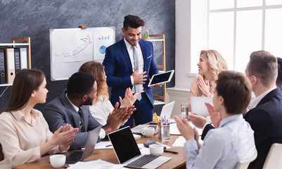 Business people applauding for colleague after presentation