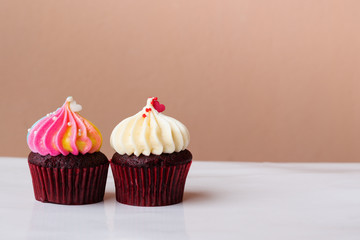 cute cupcake dessert with small  heart on white and rainbow cream on pink background
