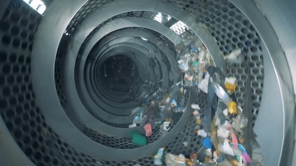 Lots of garbage rotates at a factory. Sorting process of household trash.