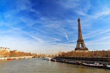 Beautiful Eiffel tower at the Seine river with a dramatic sky in winter