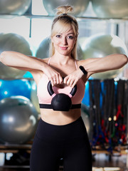 Young sporty woman stretching at gym.