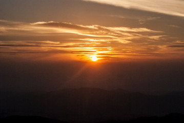 sunset with colorful sky, sun and few clouds