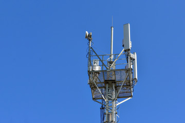 Fototapeta na wymiar Cellular antenna tower against blue sky. Top of steel mast. copy space for text