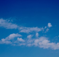 The thin white cloudscape in the bright blue sky.