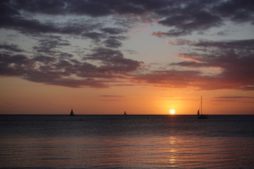 地平線に浮かぶ夕日とヨット
