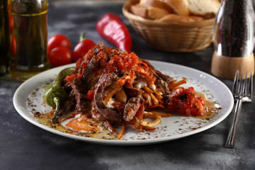 steak slices with tomato sauces and onion and yoghurt on a wooden background