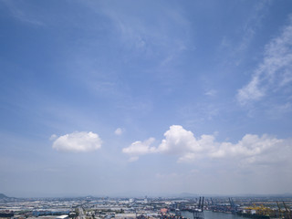 Aerial view of logistics concept floating dry dock servicing cargo ship and commercial vehicles, cars and pickup trucks waiting to be load on to a roll-on/roll-off car carrier ship at Laem Chabang 