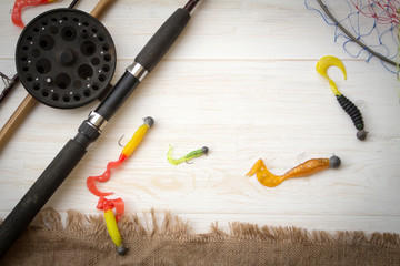 Fishing tackle-fishing spinning rods, hooks, floats and lures on wooden background