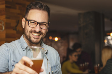 Guy with glass of beer in hand smile