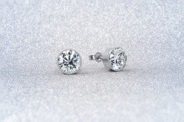 beautiful white diamond stud earrings with reflection on background