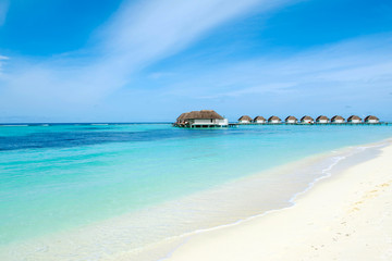 Beautiful sandy beach and over water tropical bungalo