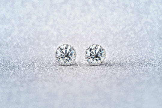 beautiful white diamond stud earrings with reflection on background
